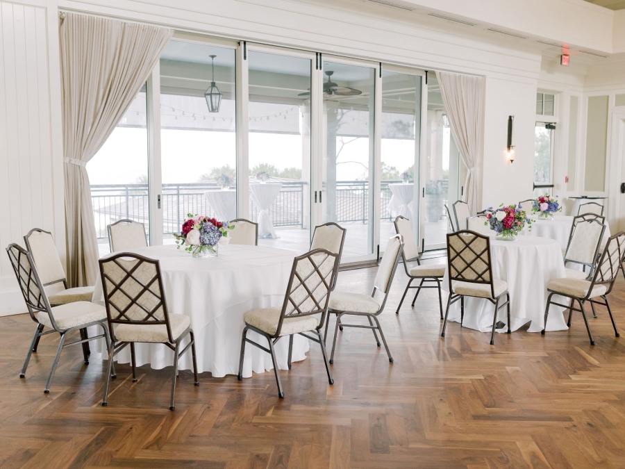The Atlantic Room at the Sea Pines Beach Club set with 8 person round tables set for a wedding. 