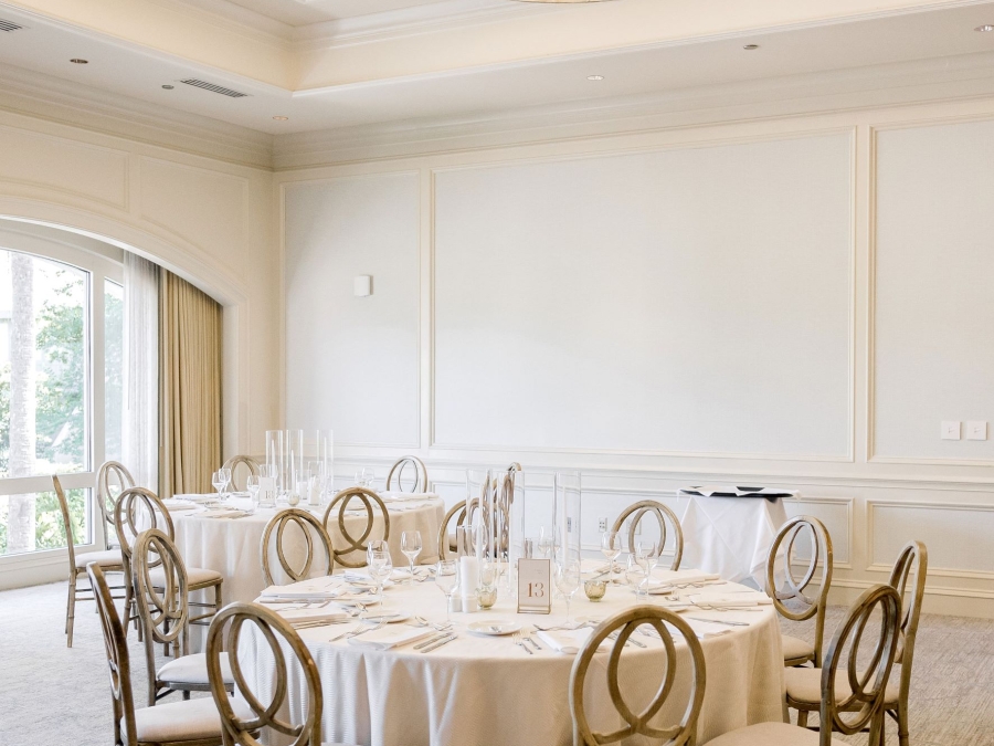 The Irwin Room in the Champions Ballroom at the Harbour Town Clubhouse setup for a wedding with large round tables. 