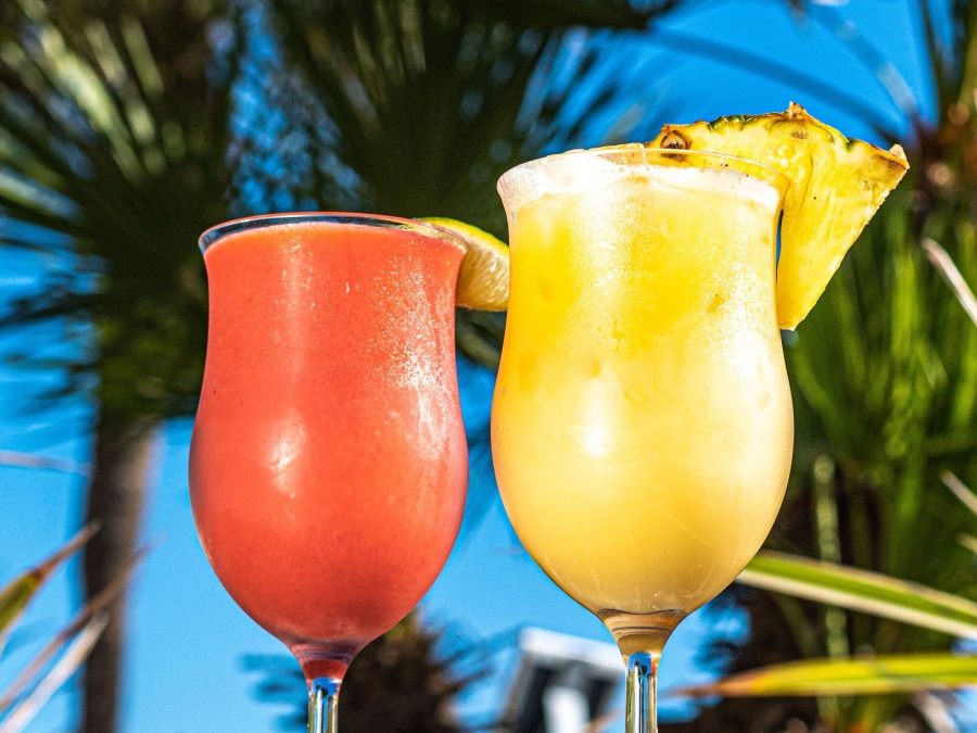 Two cocktails with palm trees in the background 