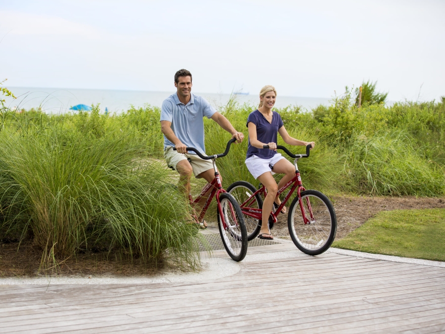 couple biking from the beach