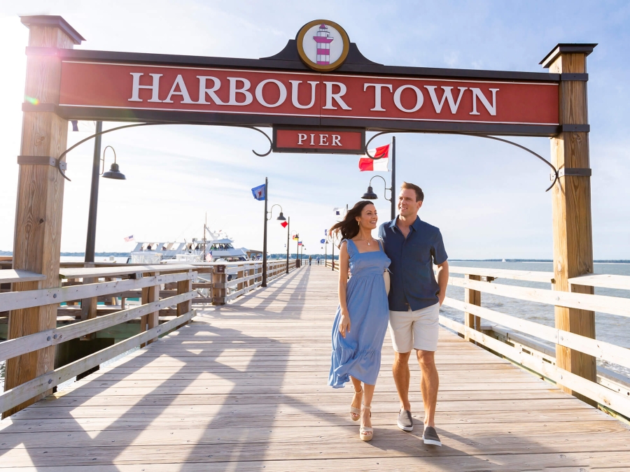 A couple walking along the harbour town pier 