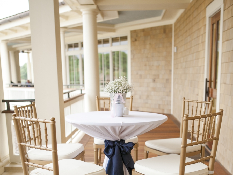 A high-top table for two set up on the Magnolia Porch at the Plantation Golf Club. 