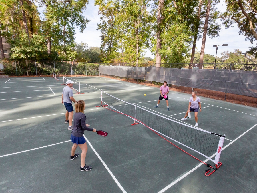 Four people playing pickleball