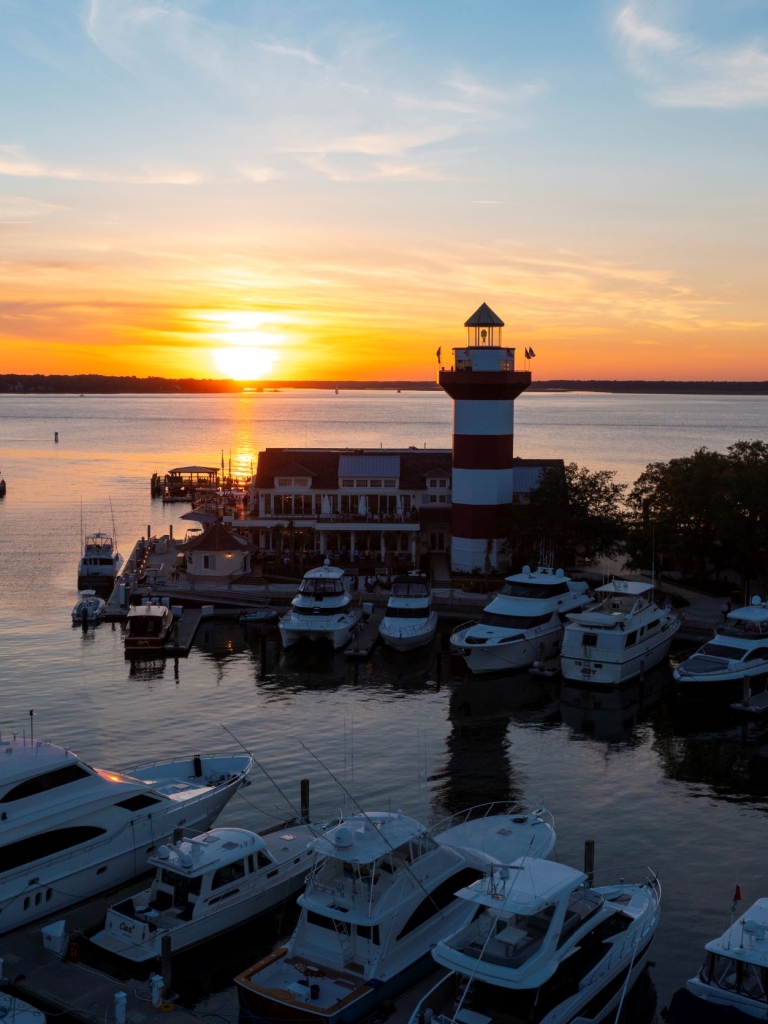 A view of the Quarterdeck restaurant and the Harbour Town Lighthouse in the Harbour Town Yacht Basin at sunset over the Calibogue Sound. 