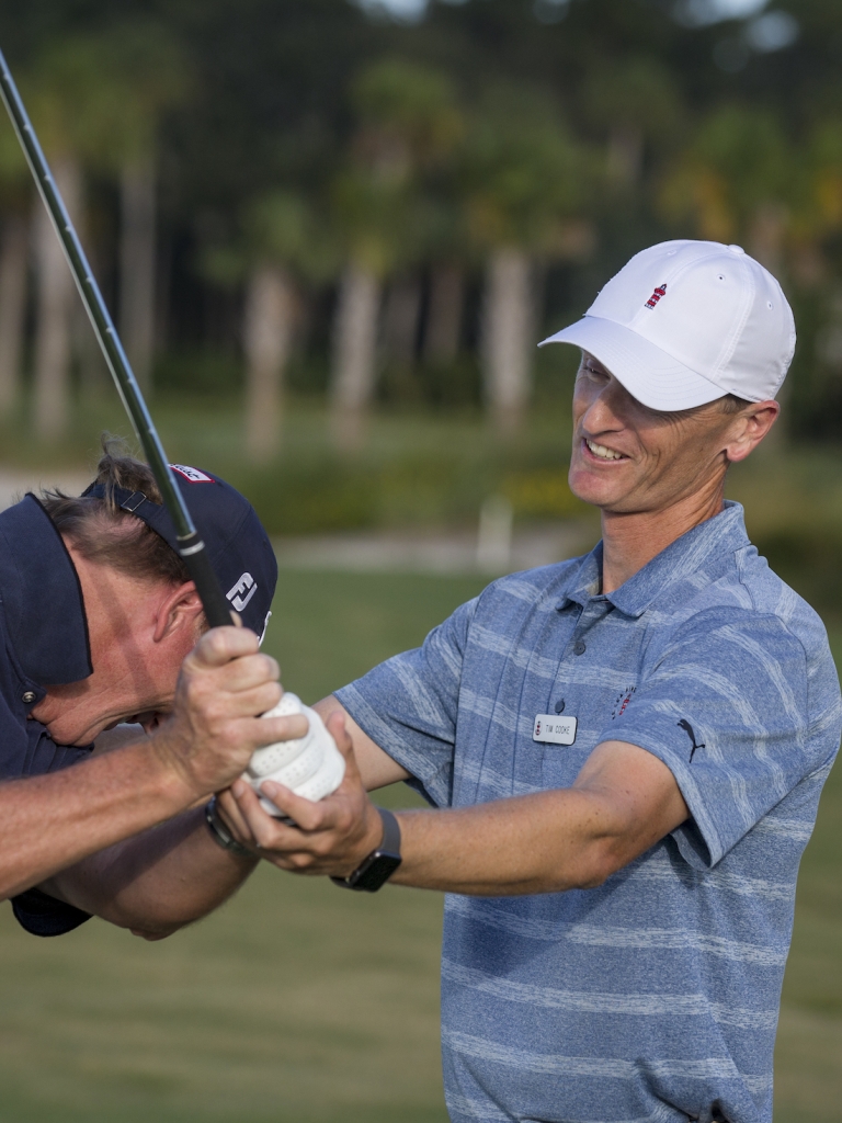 Golf coach teaching a man 