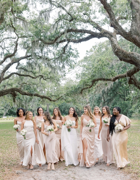 Girls bridal party posing under trees 