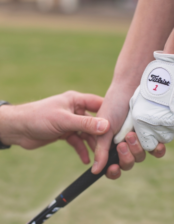 Close up image of a person holding a golf club 