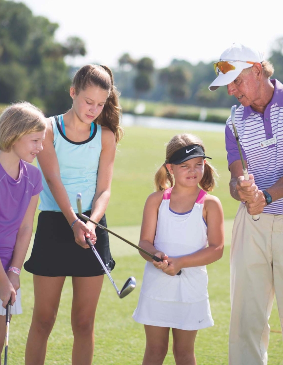 Golf coach teaching a group of children  