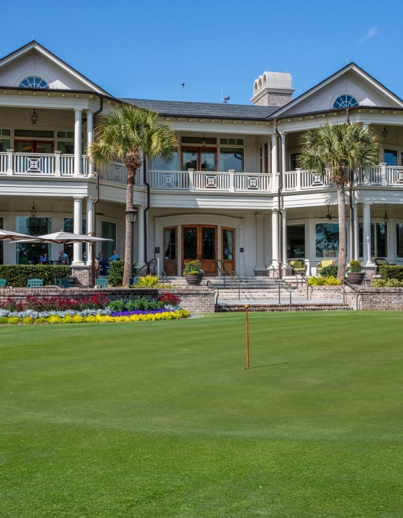 Man golfing in-front of Links restaurant 