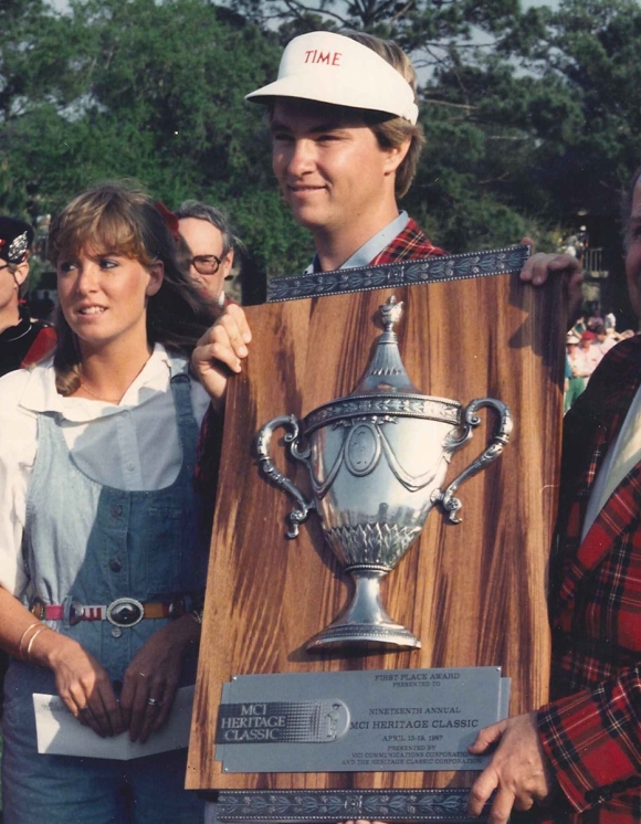 Image of a golf champion and 3 others holding a trophy 