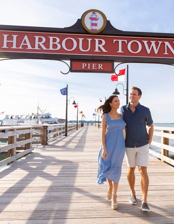 Couple walking along harbour town pier 