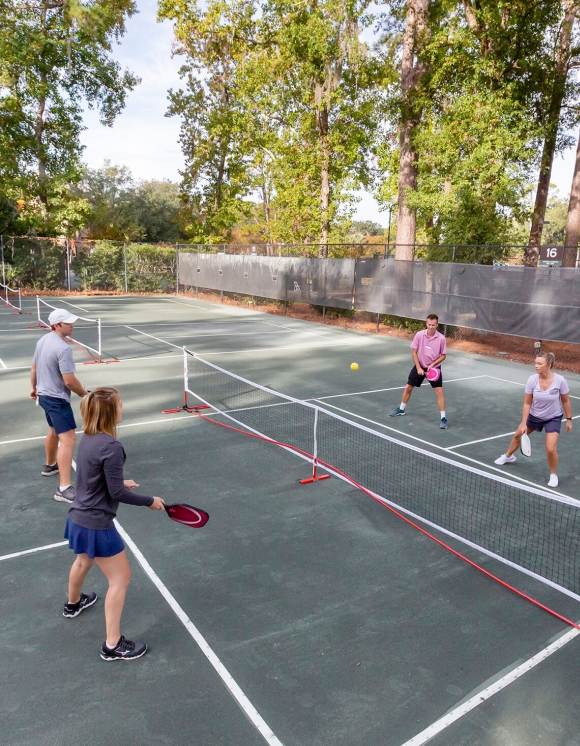 Four people playing pickleball 