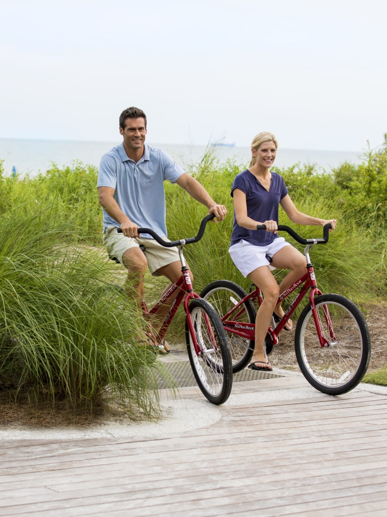 couple biking from the beach