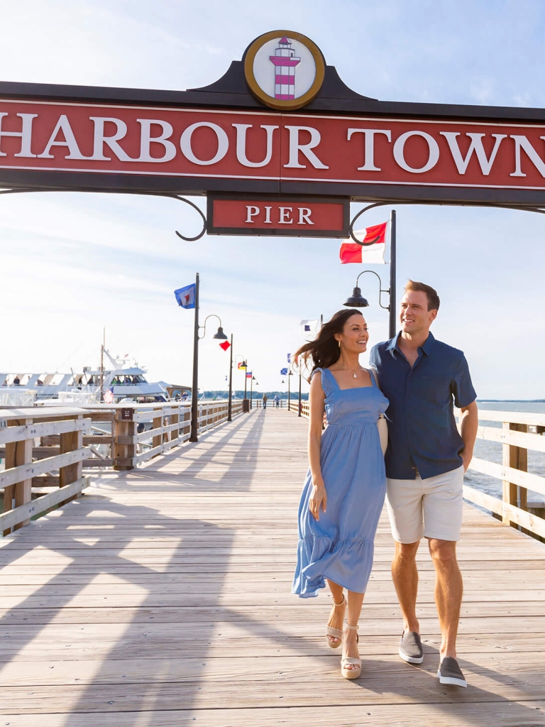 A couple walking along the harbour town pier 