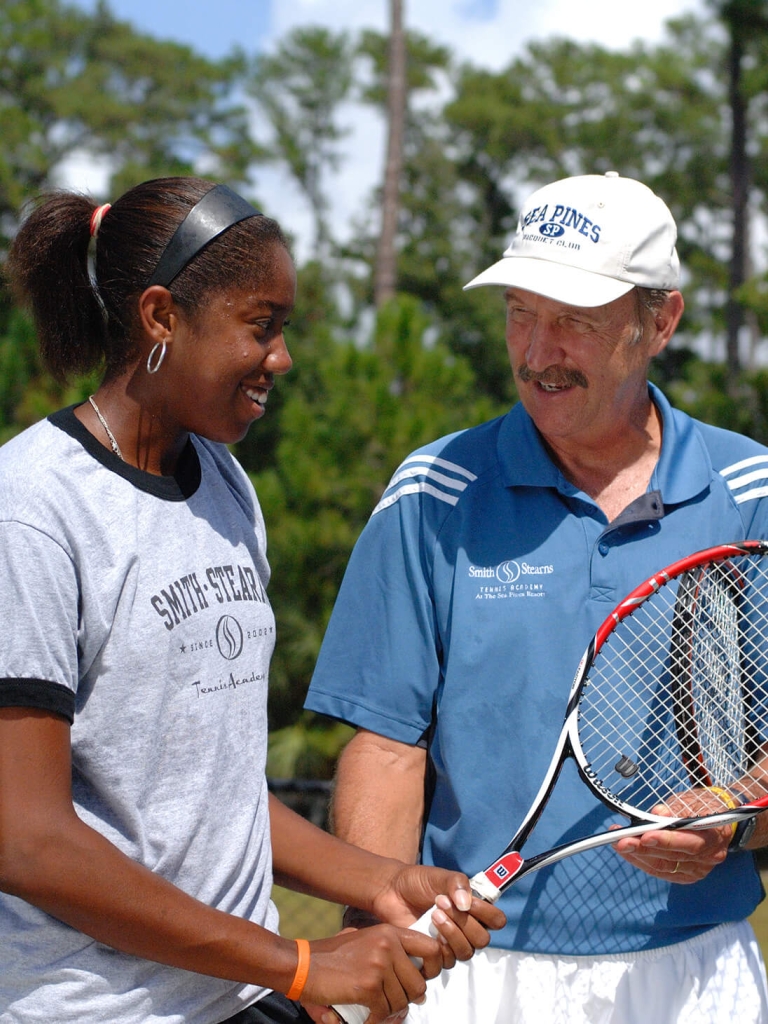 Instructor teaching a women tennis