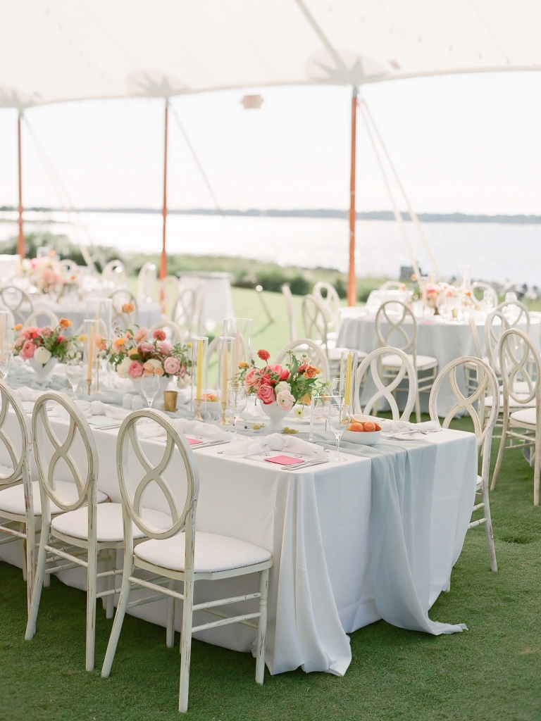 Table with wedding decor under a tent outside 