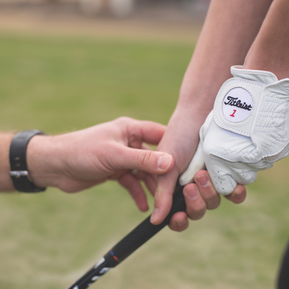 Close up image of a person holding a golf club 