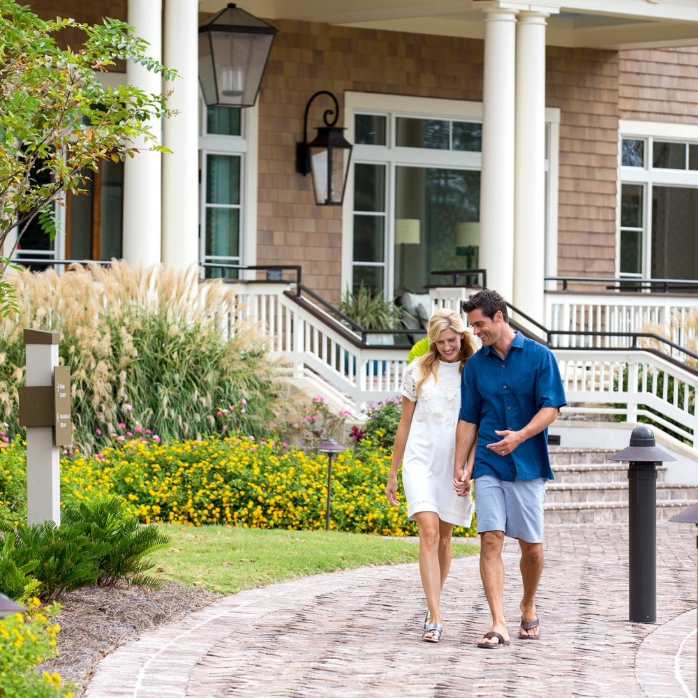 Man and women walking with the golf club in the background