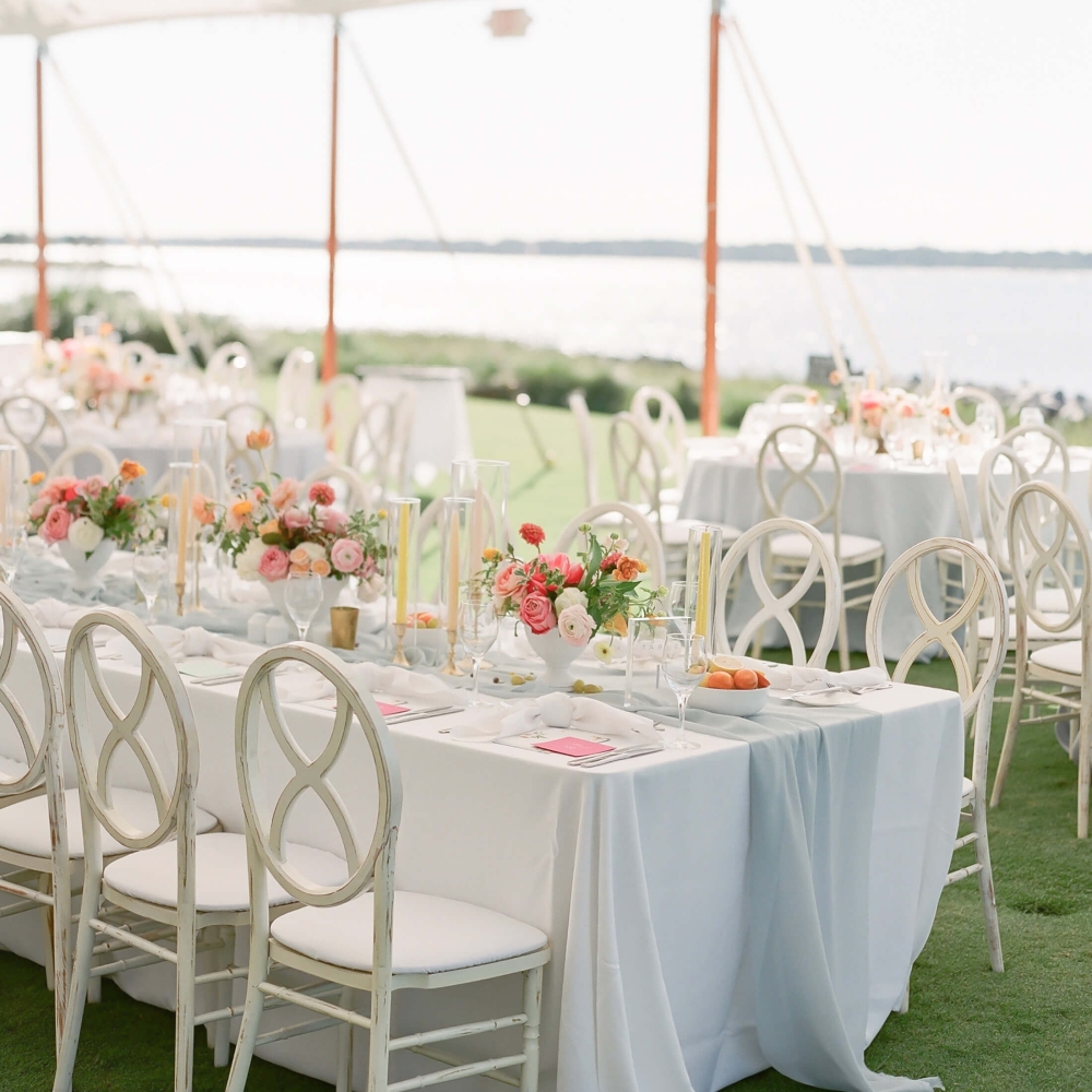 Table with wedding decor under a tent outside 