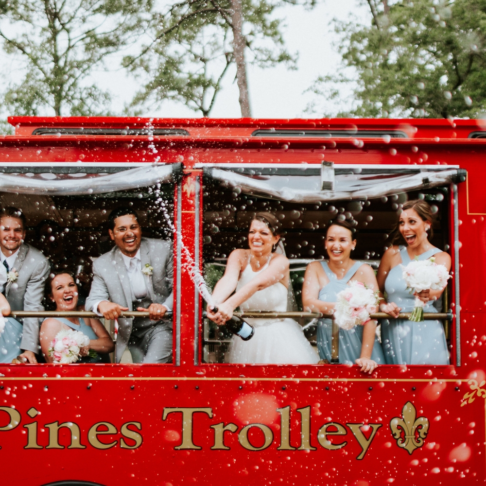 Wedding party popping champagne on a red trolley 