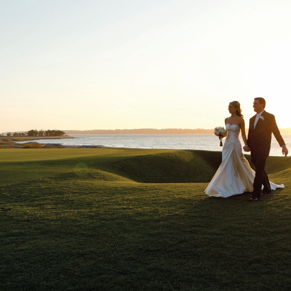 Married couple walking along the golf course 